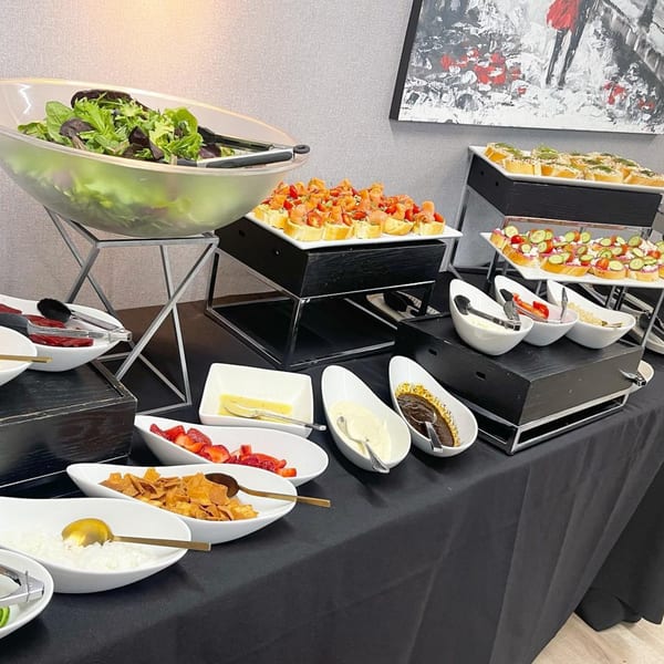 A Mediterranean buffet with salads, bruschetta, and various toppings on a black tablecloth.