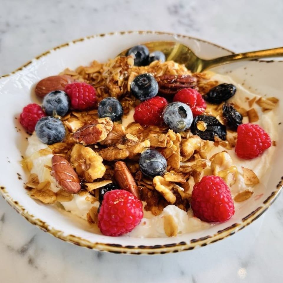 Olia Restaurant's yogurt bowl with granola, fresh raspberries, blueberries, nuts, and honey.
