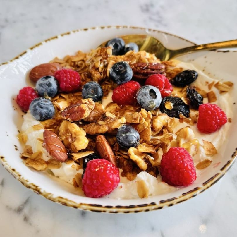Olia Restaurant's yogurt bowl with granola, fresh raspberries, blueberries, nuts, and honey.